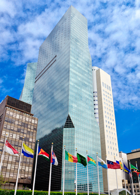 a tall building with many flags with New Museum in the background
