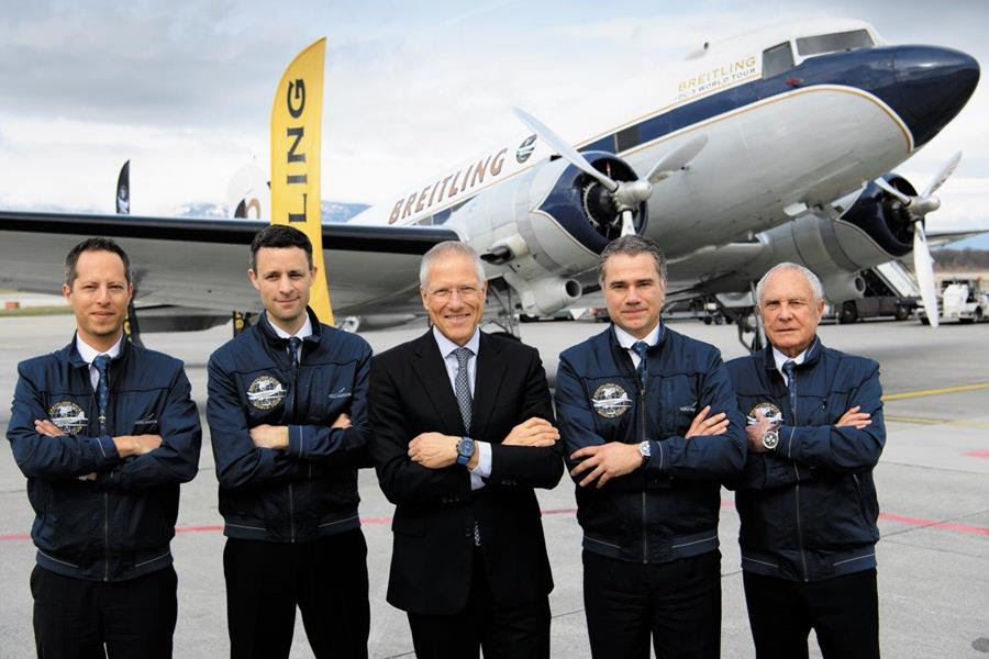 a group of men standing in front of an airplane