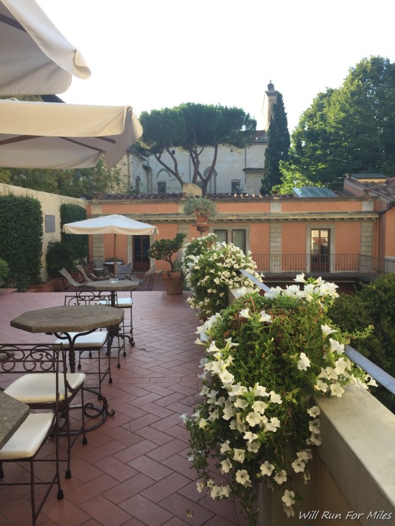 a patio with white flowers and a building