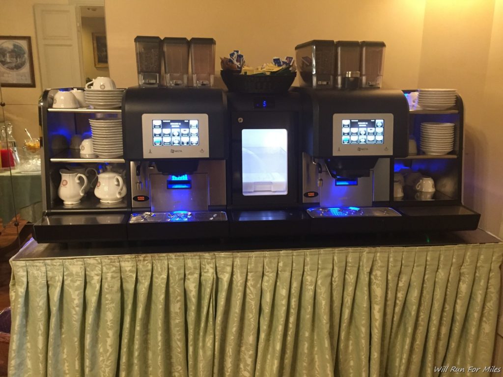a coffee machine with a few cups and plates on top