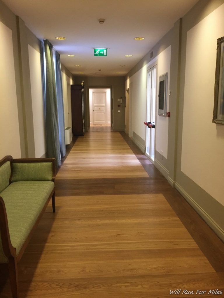 a long hallway with a bench and a wood floor