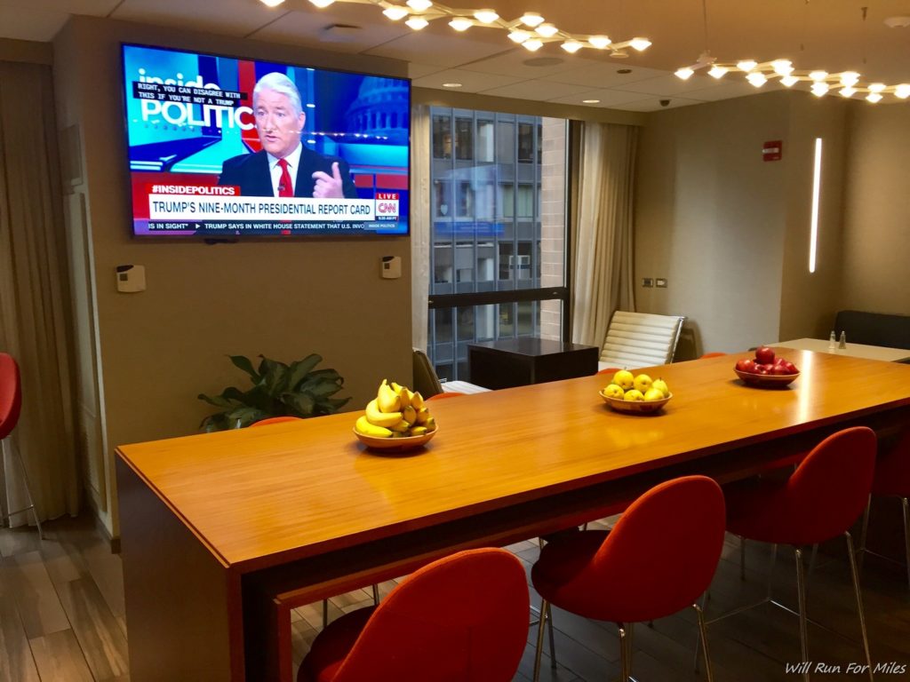a table with fruit bowls and a television on the wall