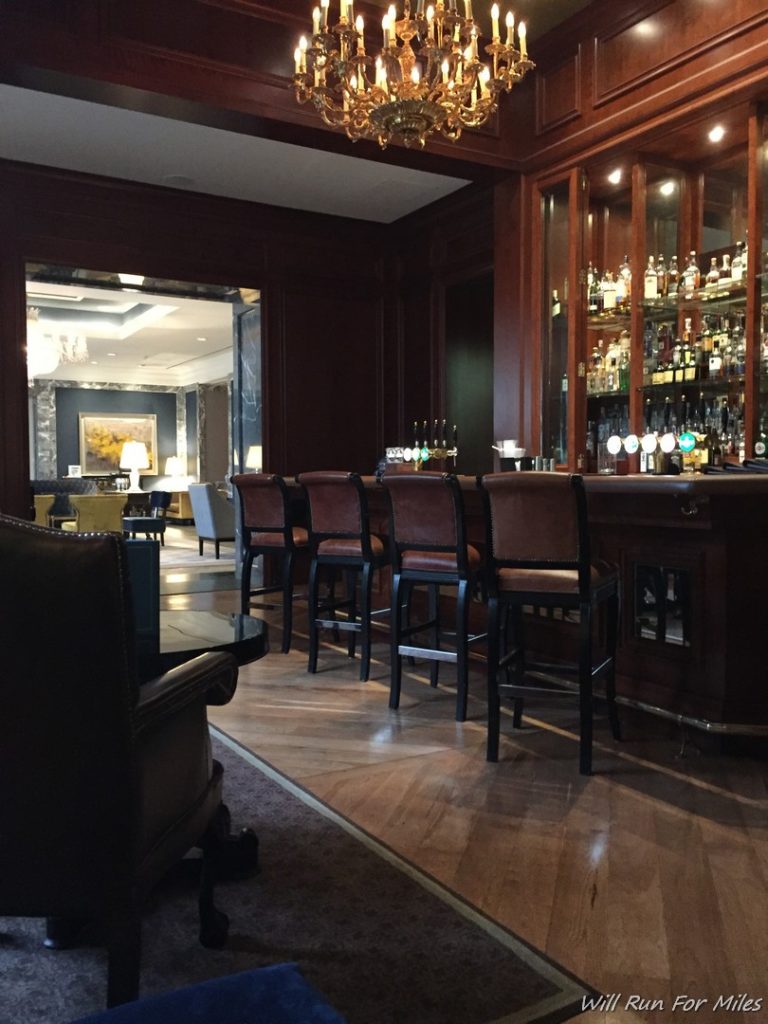 a bar with chairs and a bar in a room