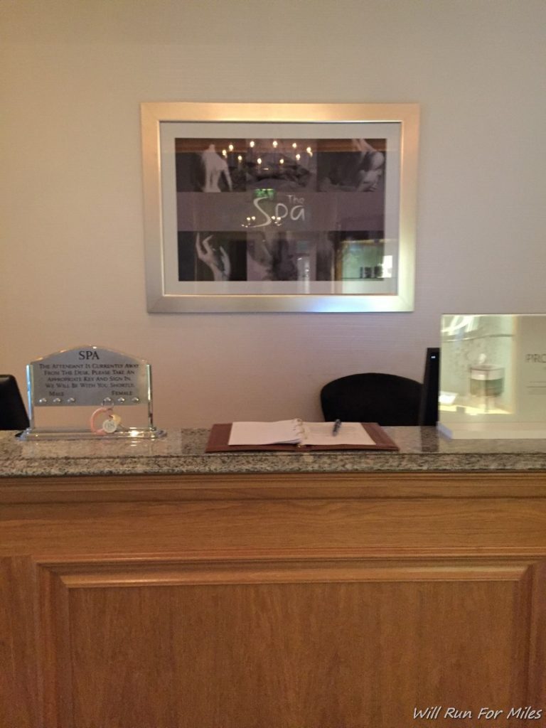 a reception desk with a sign and a picture on the wall