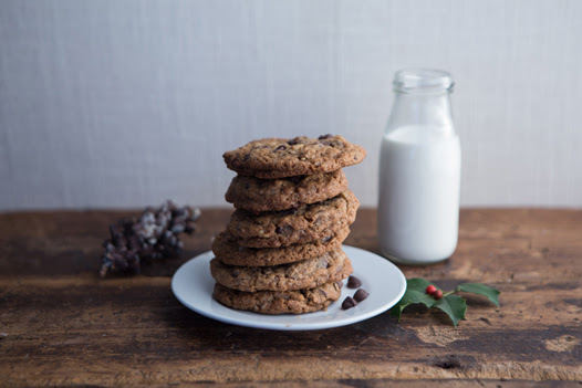 a stack of cookies on a plate next to a bottle of milk