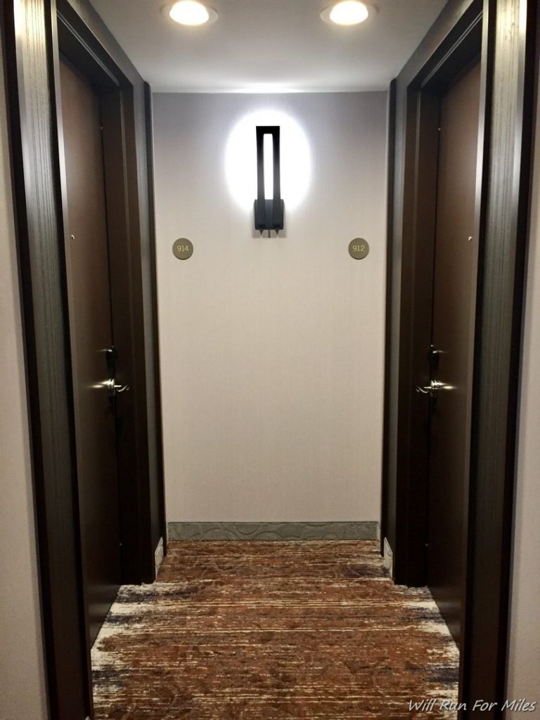 a hallway with two doors and a light on the wall