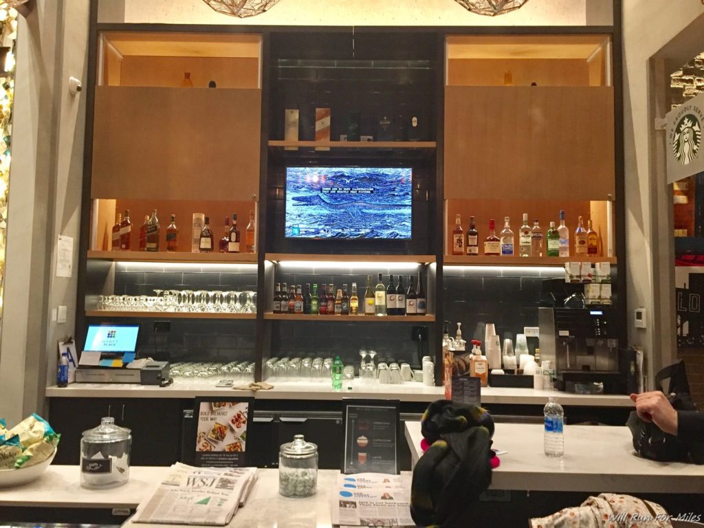 a bar with shelves of liquor and a television