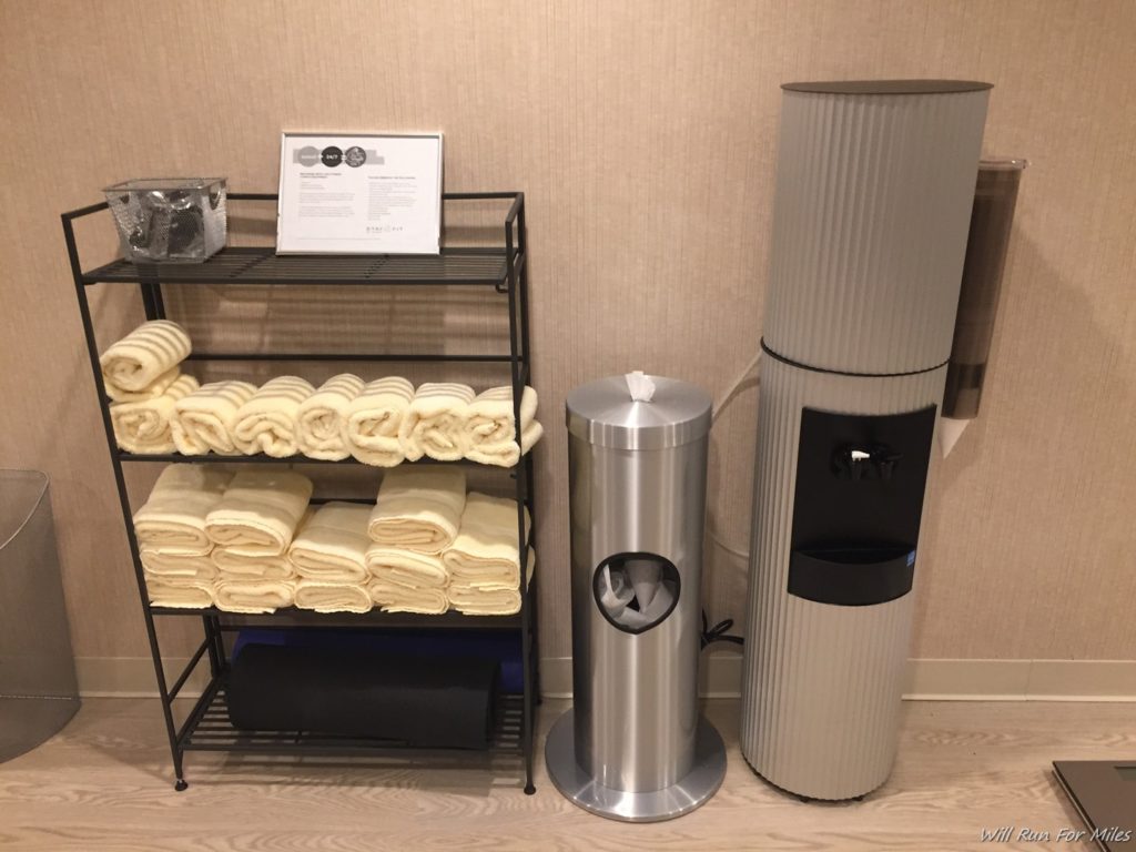 towels on a shelf next to a water cooler