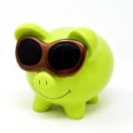 a green piggy bank with sunglasses