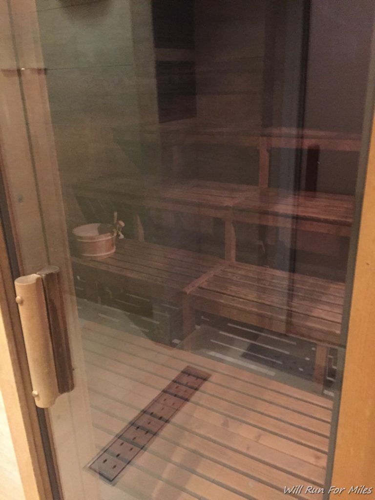 a glass door with a wooden bench and a bucket