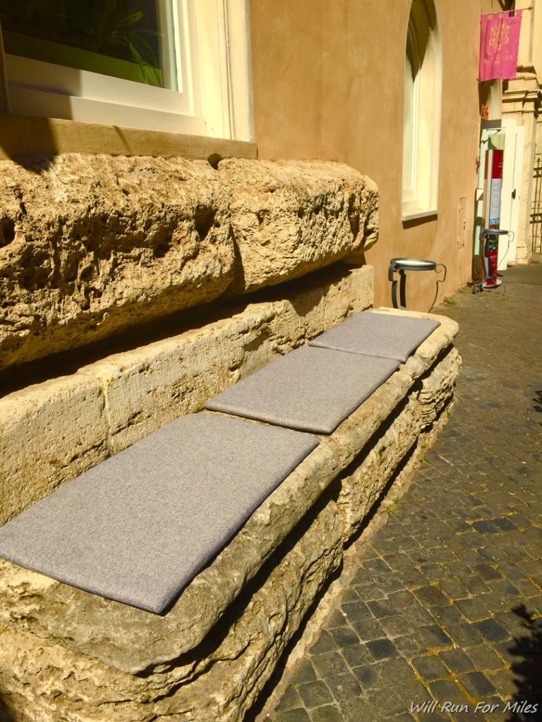 a stone bench with cushions on it