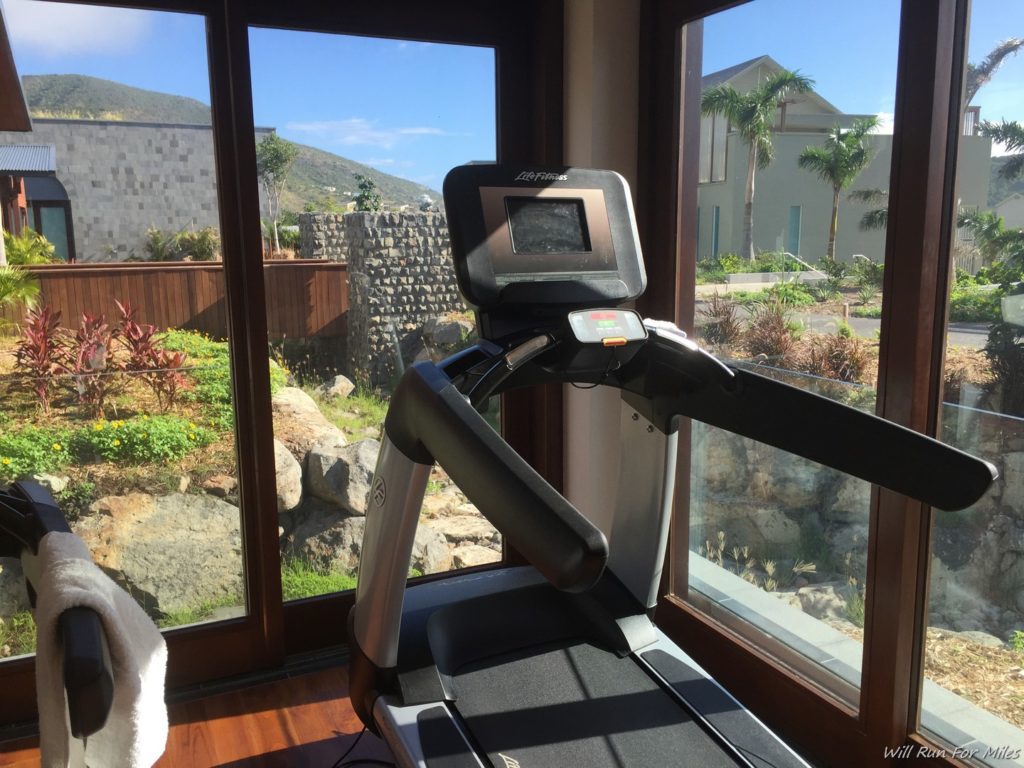 a treadmill in a room with a view of a house and trees
