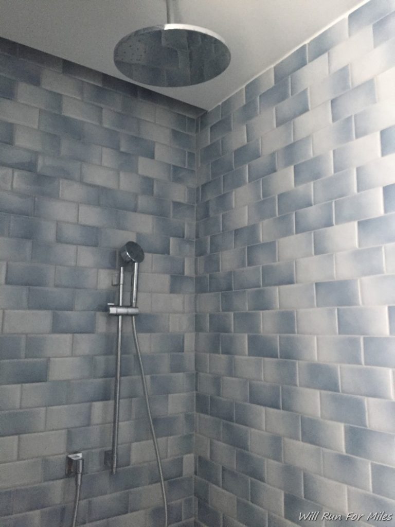 a shower with a round ceiling fan