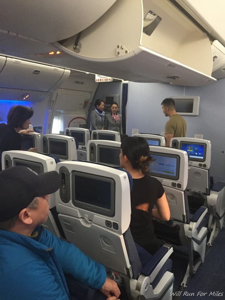 people sitting in an airplane with many monitors