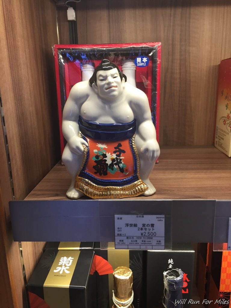 a statue of a sumo wrestler on a shelf
