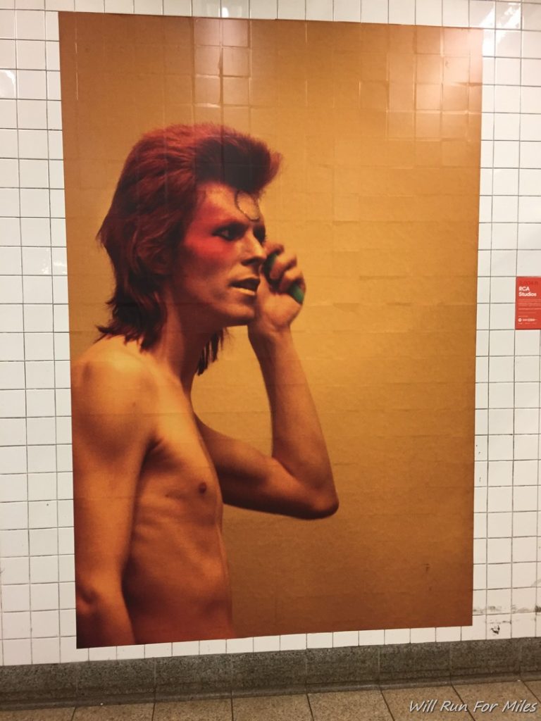 a man with red hair and a painted face on a tile wall