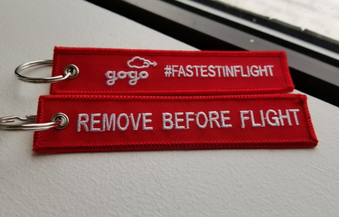 a red fabric keychain with white text