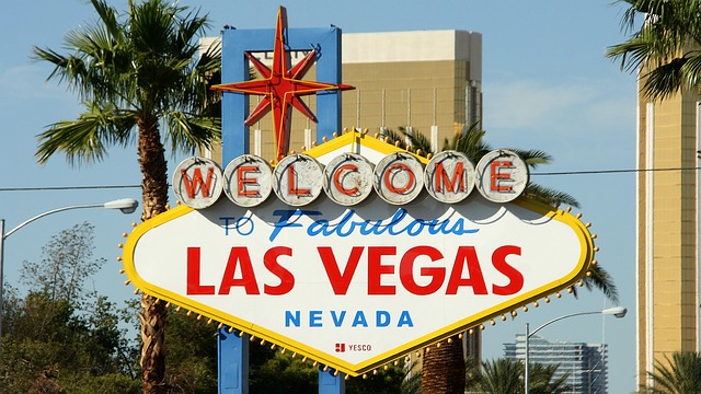 a large sign with palm trees with Welcome to Fabulous Las Vegas sign in the background
