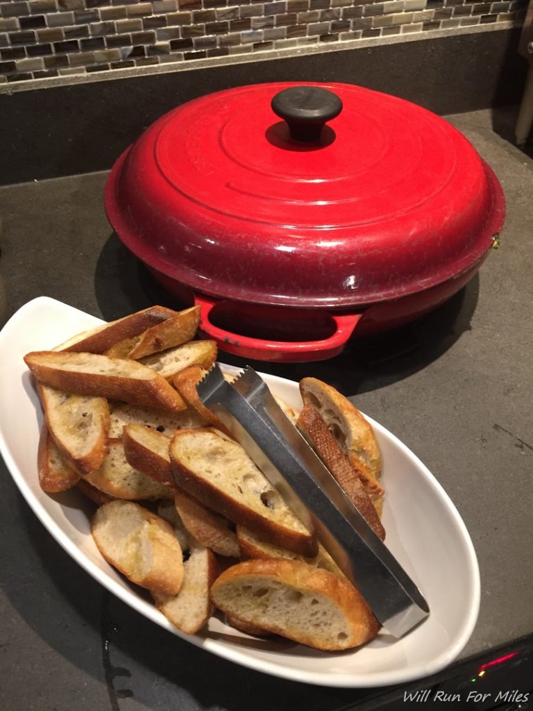 a plate of bread with a tong next to a red lid