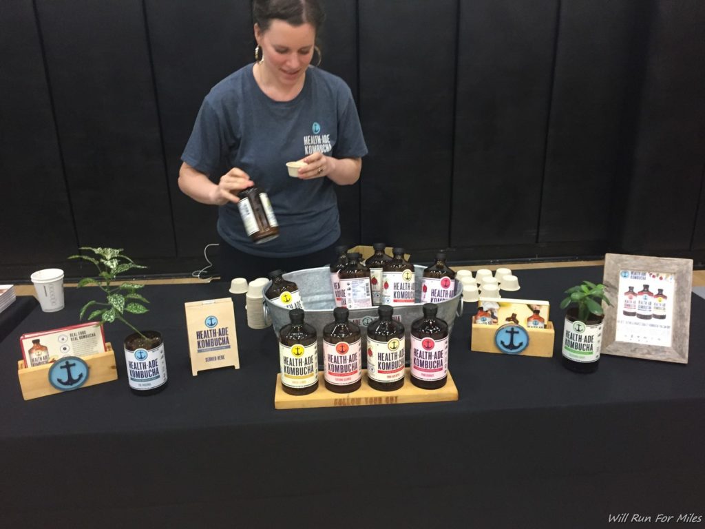 a woman standing next to a table with bottles