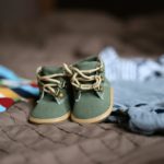 a pair of baby shoes on a bed