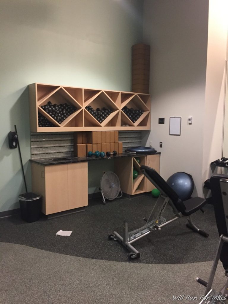a room with exercise equipment and a chair
