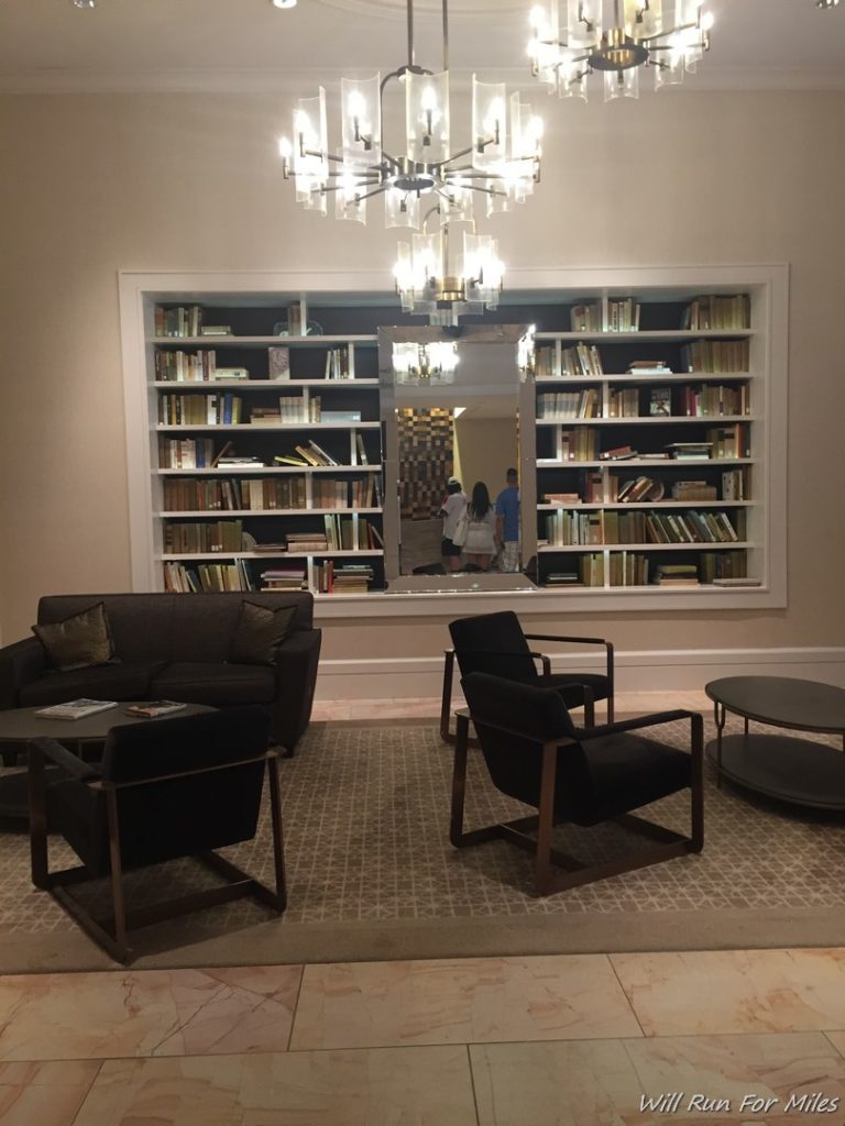 a room with a chandelier and bookshelves