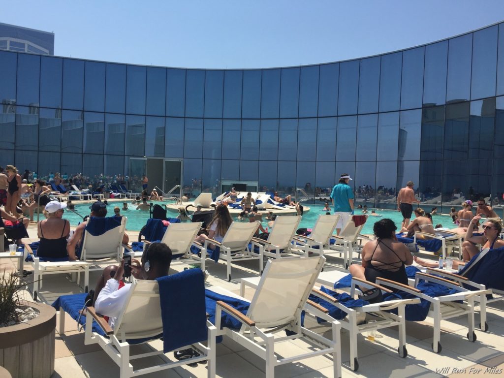 a group of people sitting in chairs by a pool