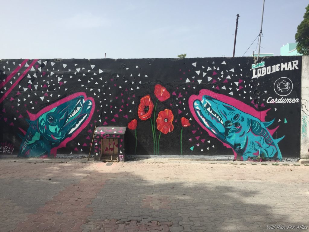 a wall with a painting of sharks and flowers