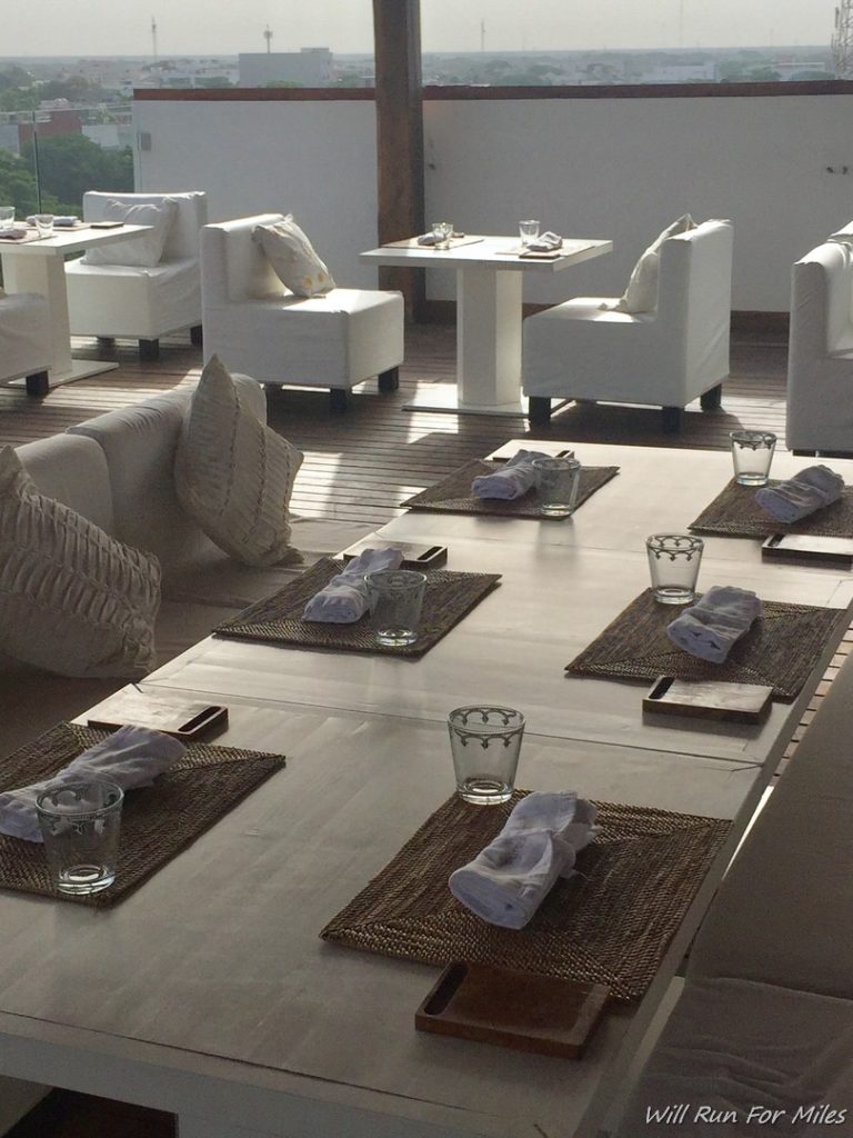 a table with white chairs and napkins