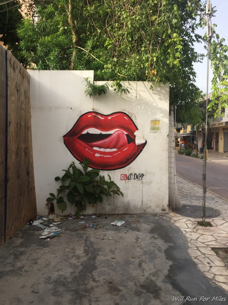a wall with a painting of lips on it
