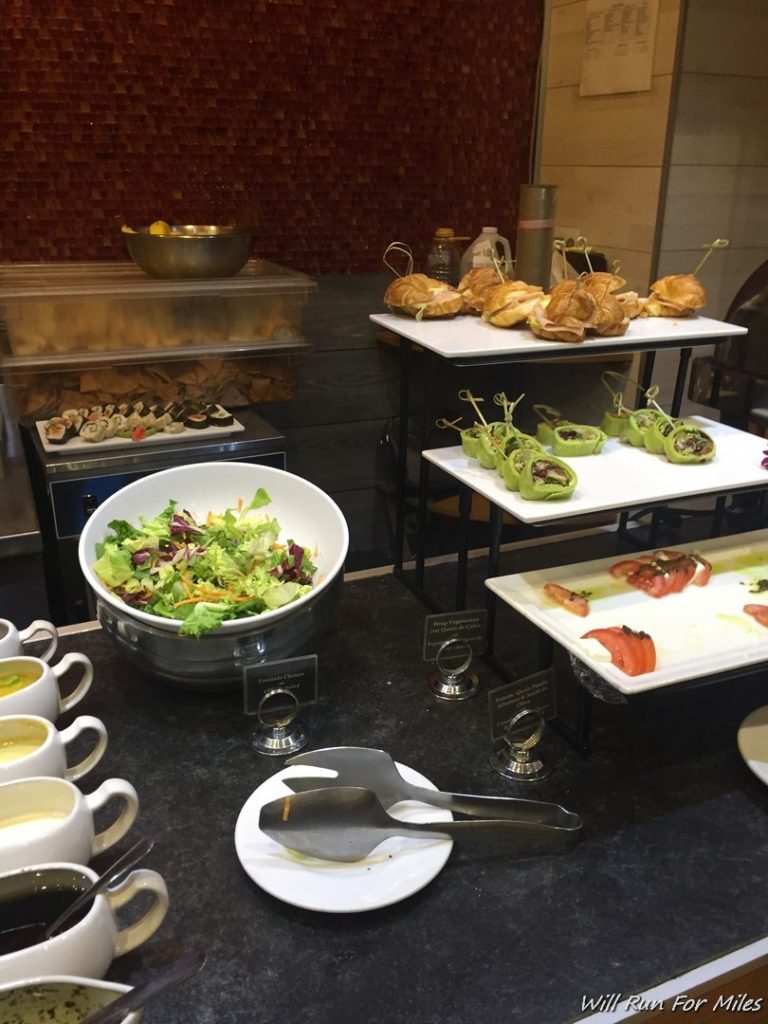 a buffet table with plates of food and salad