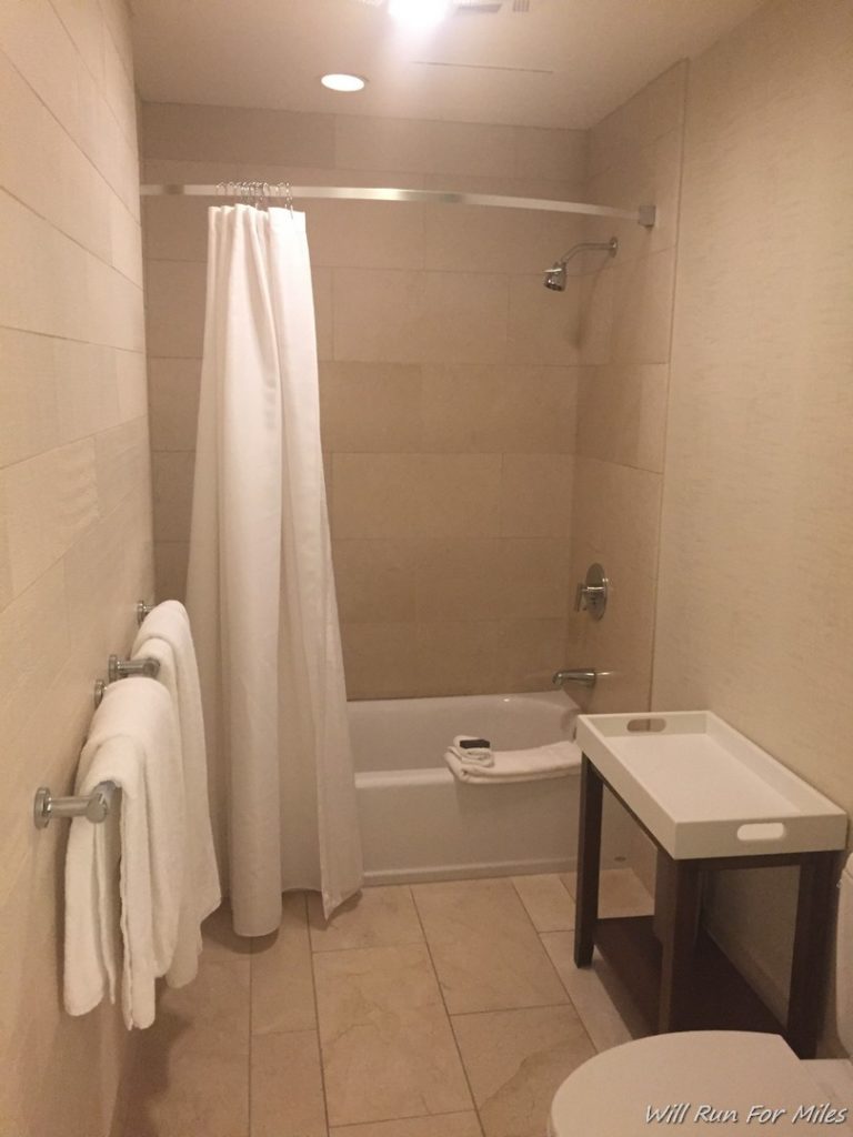 a bathroom with a shower curtain and a table