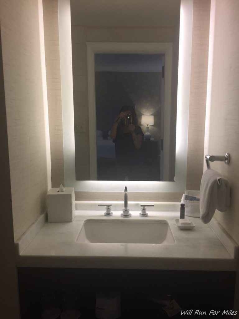 a person taking a picture of a mirror in a bathroom