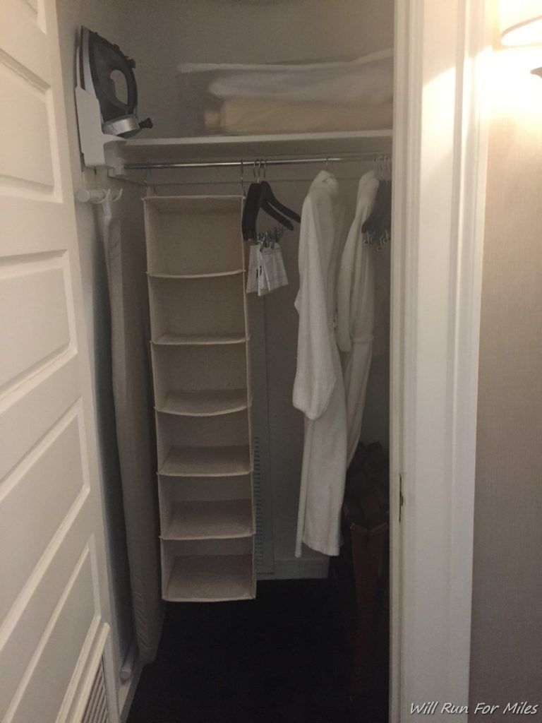 a closet with white towels on a rail