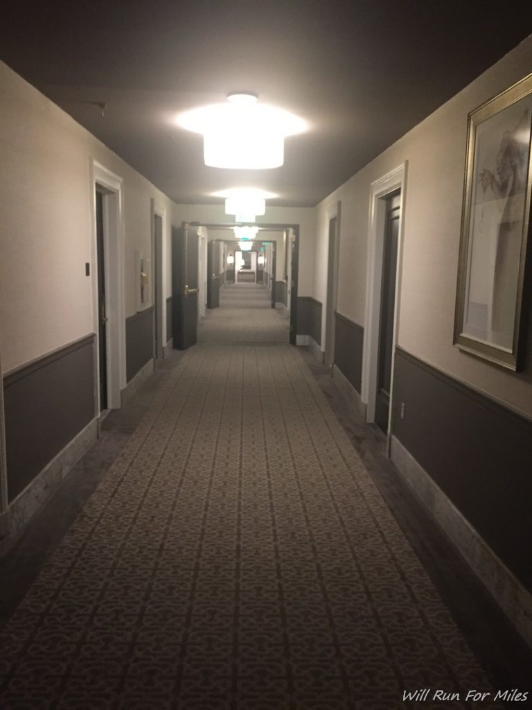 a hallway with a tile floor and a light fixture