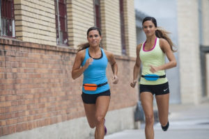 two women running on a sidewalk