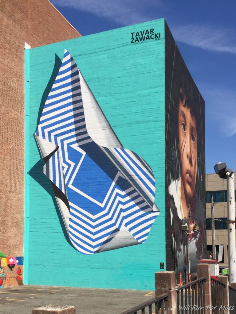a blue building with a blue and white mural on the side