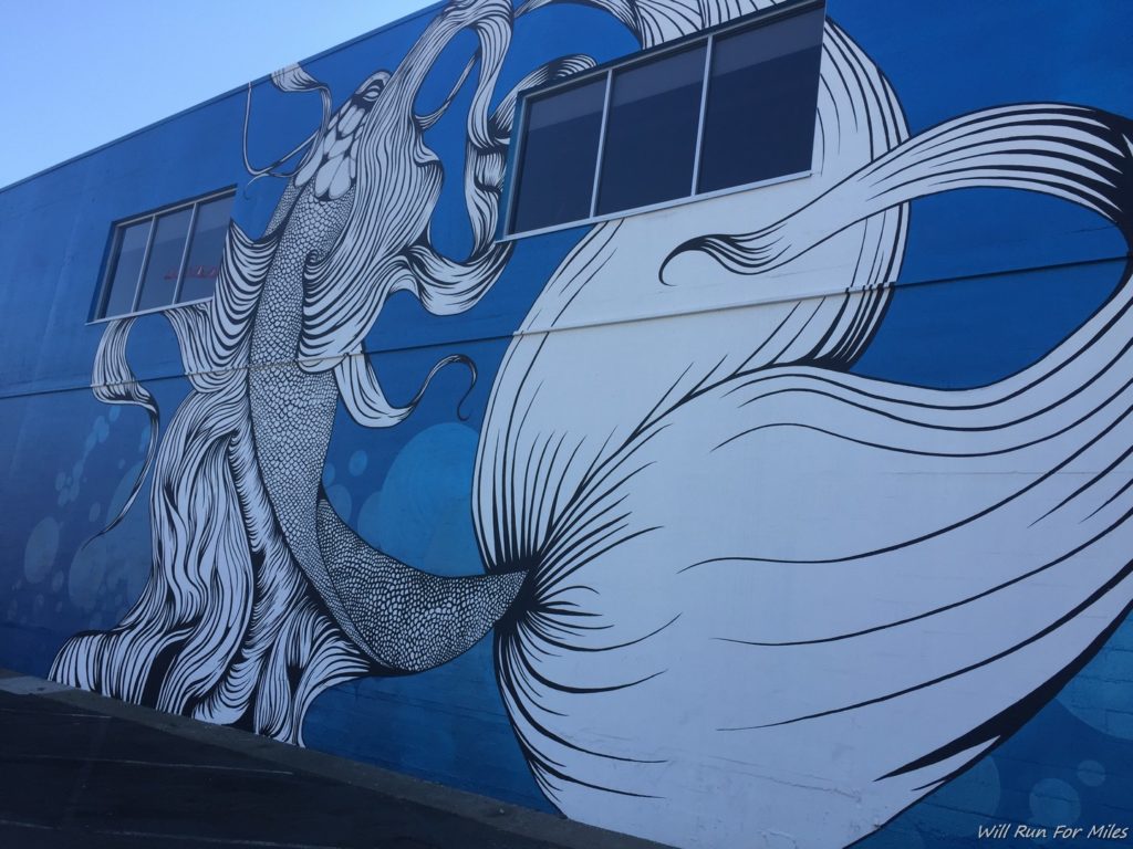a blue building with a white and black mural on it