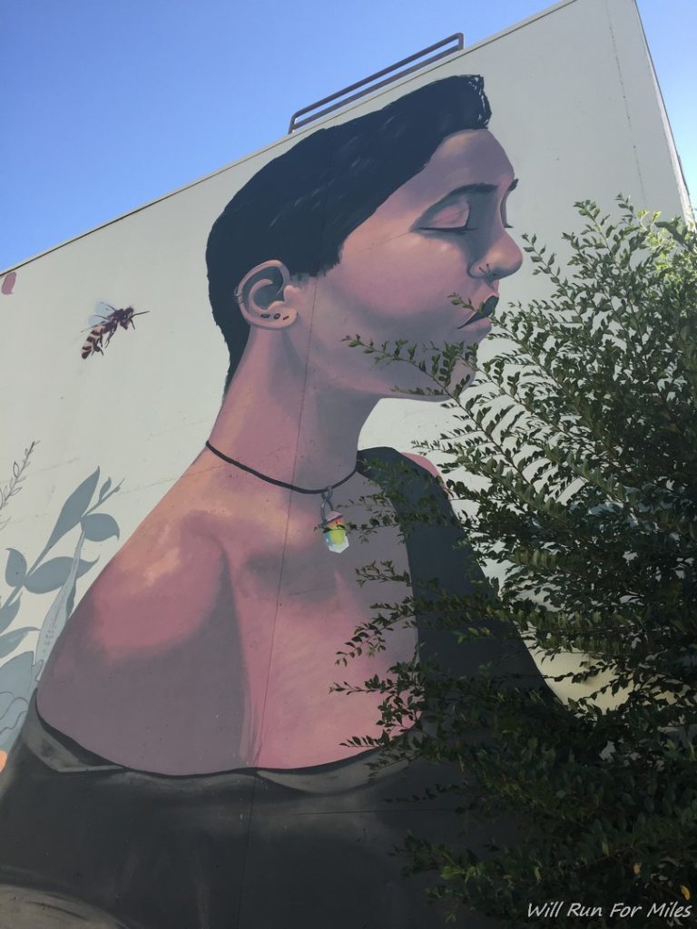 a mural of a woman with a bee on the side of her face
