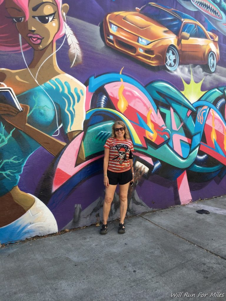 a woman standing in front of a mural