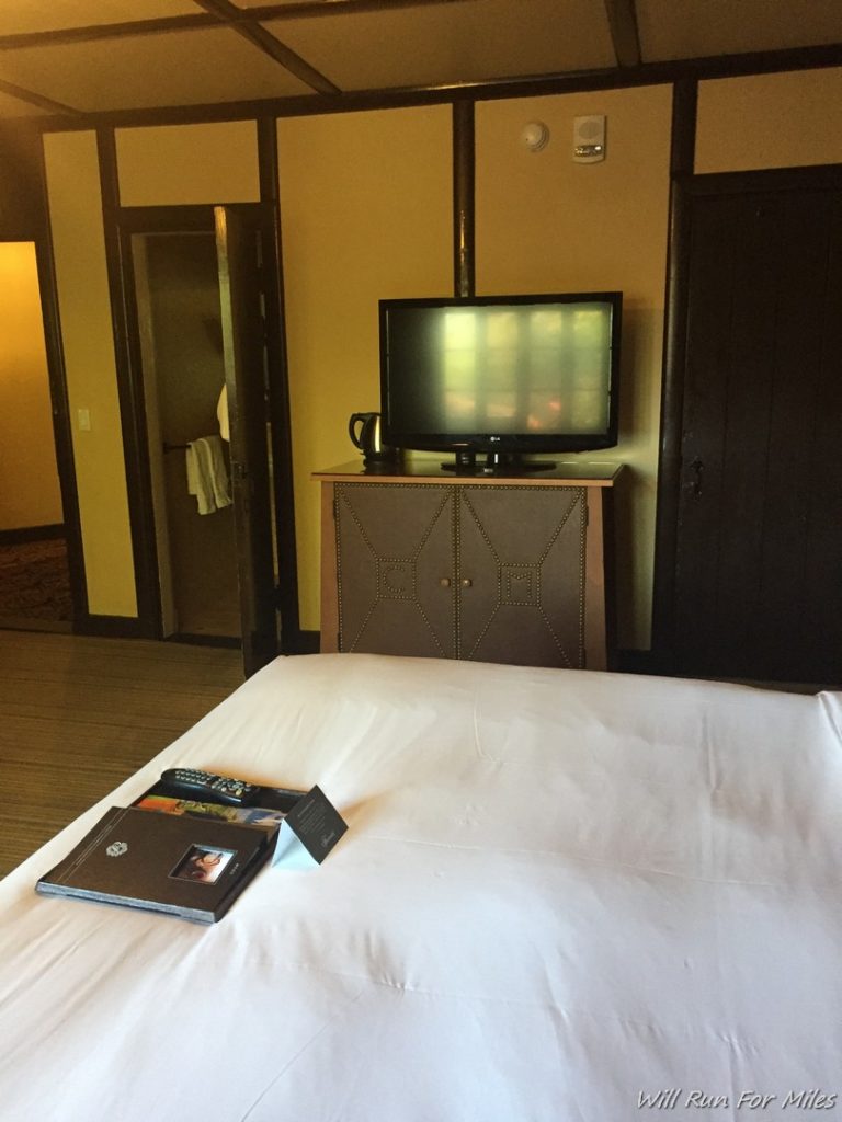 a bed with a white sheet and a tv on it
