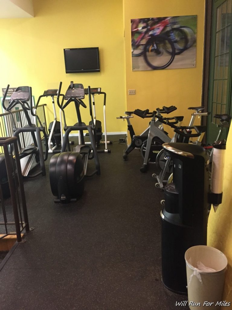 a room with exercise bikes and a television