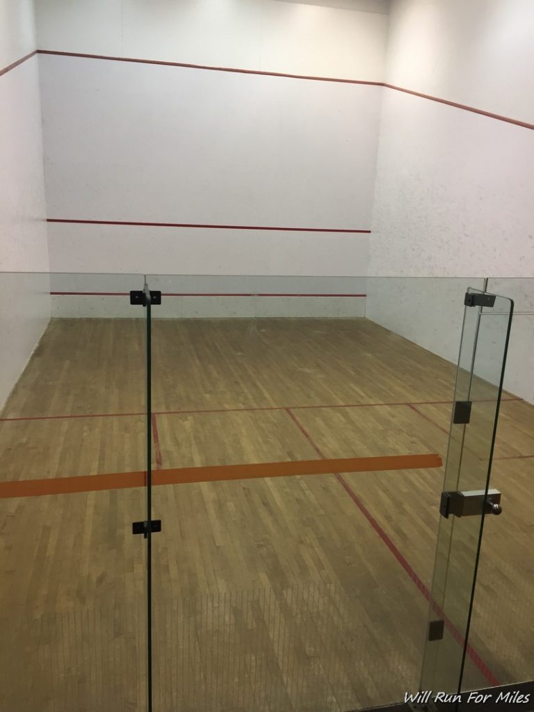 a squash court with glass doors
