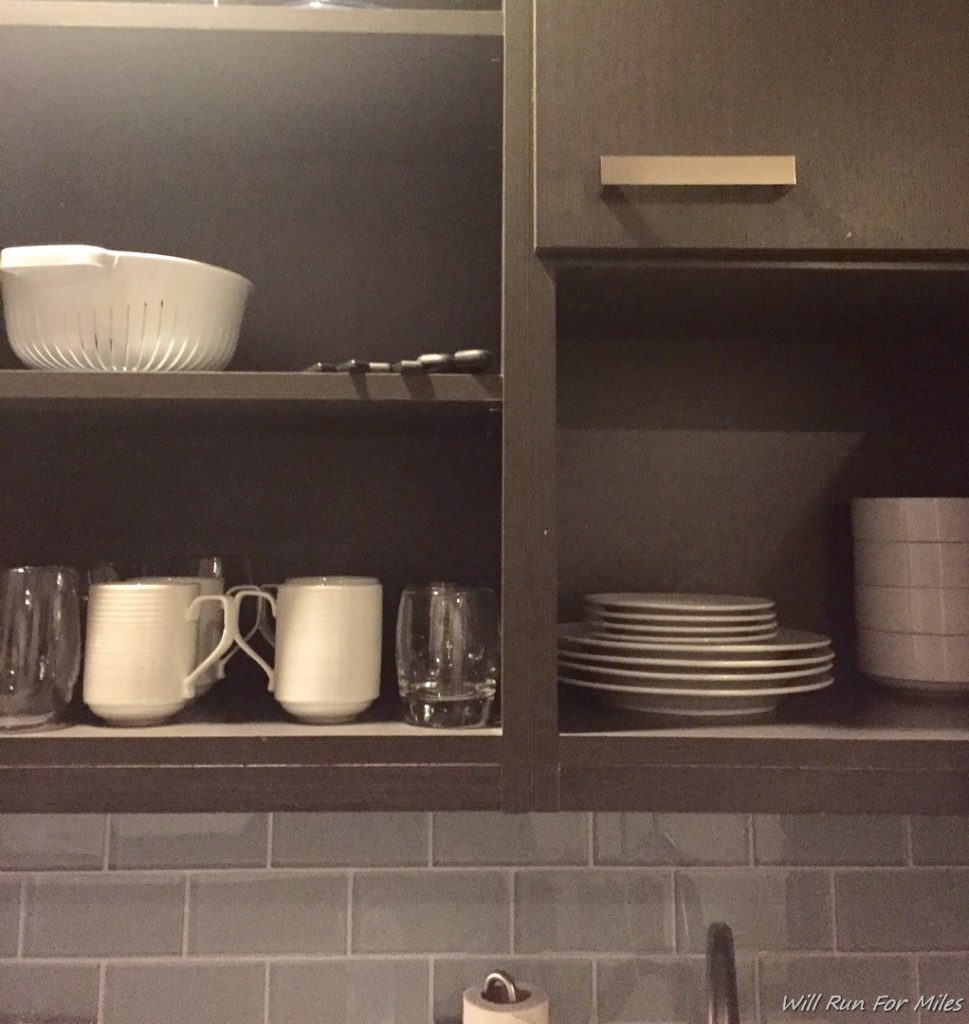 a kitchen cabinets with white dishes and plates