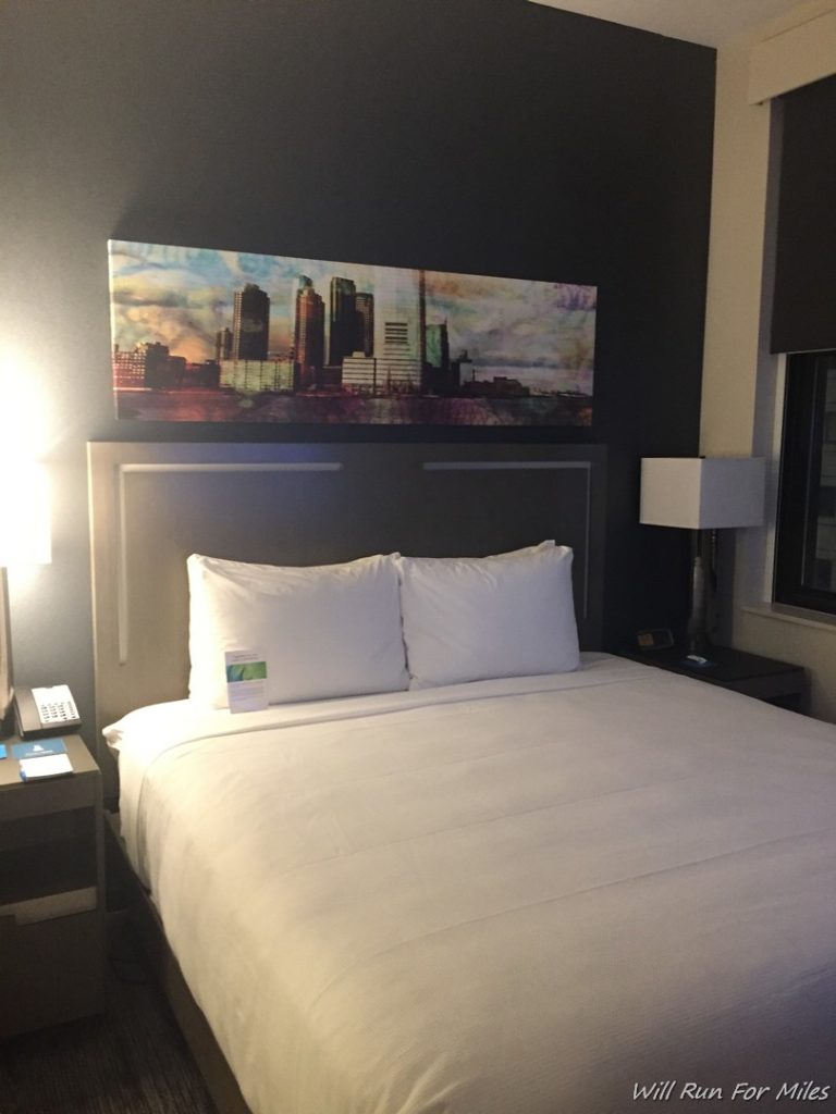 a bed with a painting above it