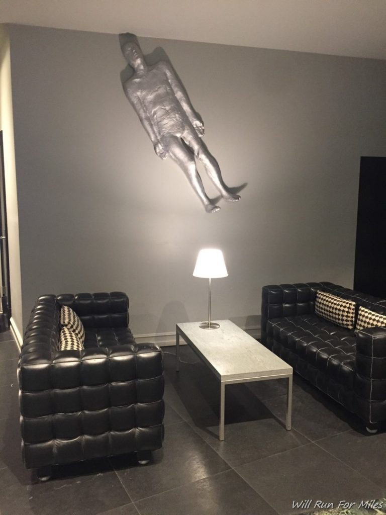 a room with a couch and a silver statue of a man