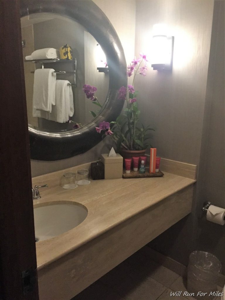 a bathroom with a mirror and a flower