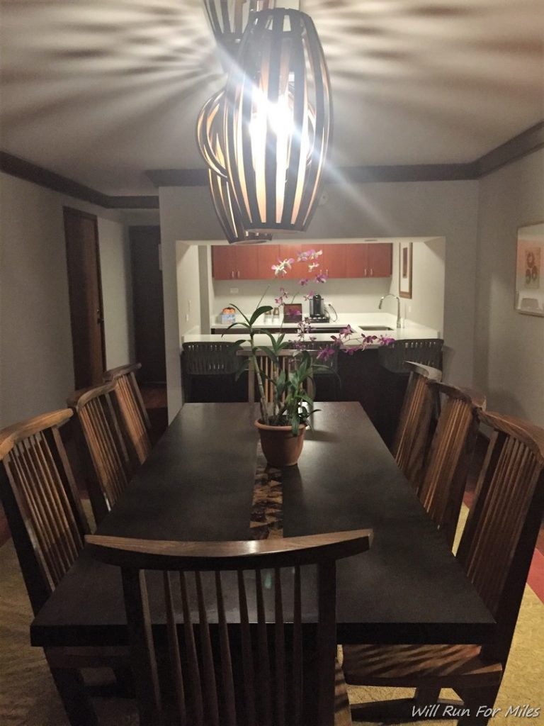 a dining table with chairs and a lamp