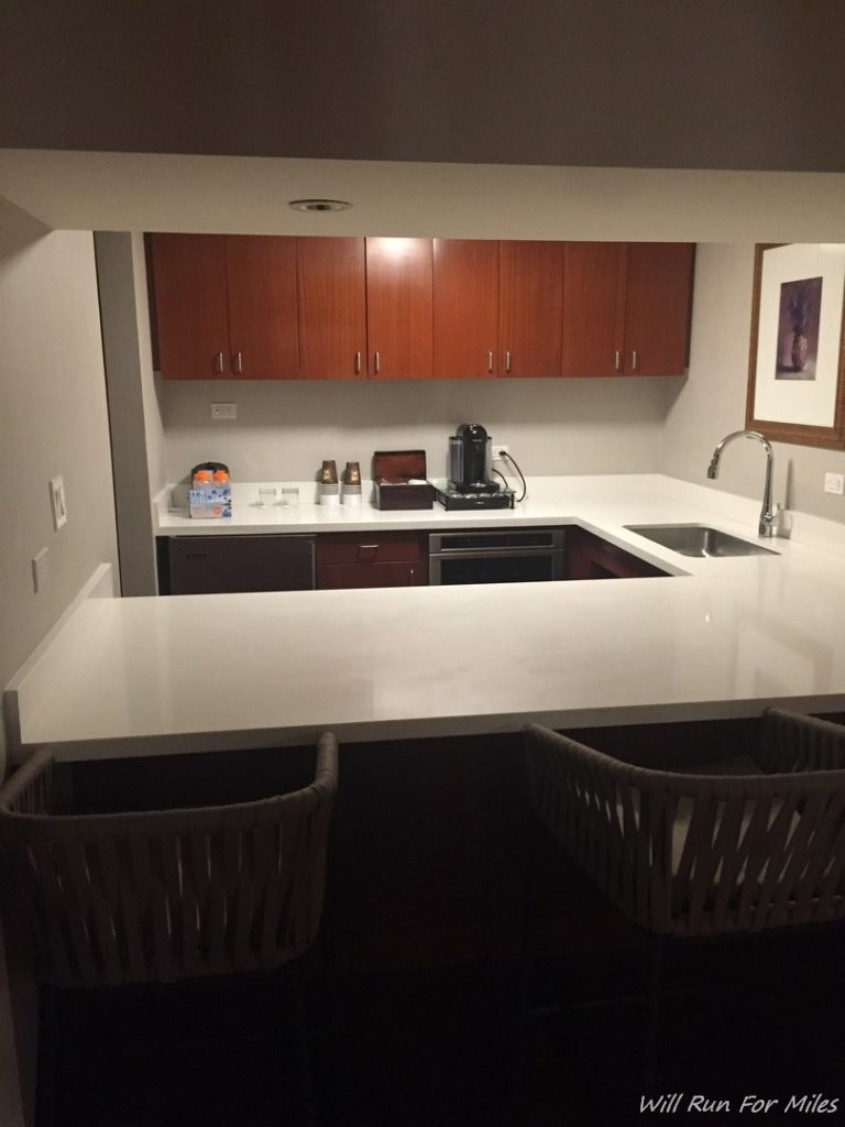 a kitchen with a white countertop and chairs